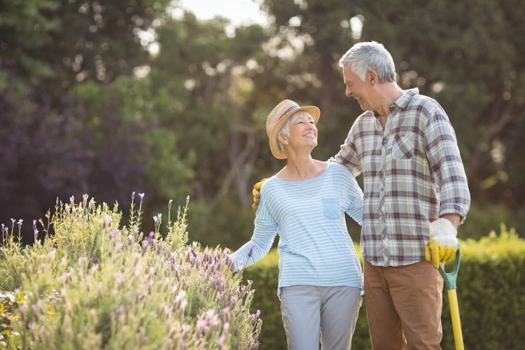 Happy senior couple standing in backyard